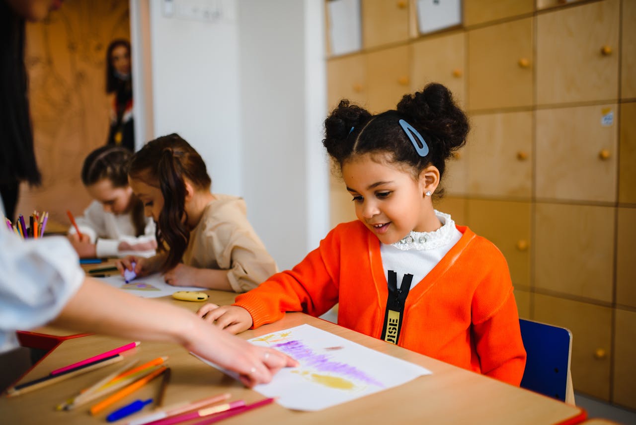 Young students happily enjoying art projects in a classroom setting.