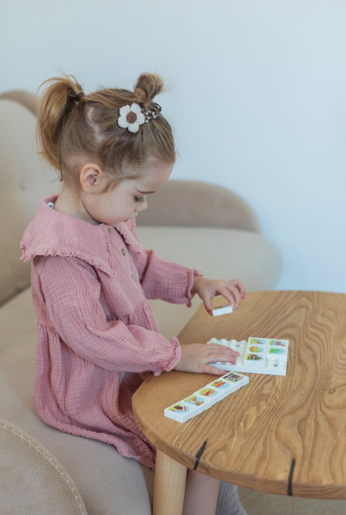 Young girl playing with an educational puzzle indoors, promoting learning and creativity.